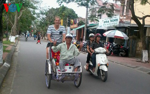 A foreign tourist tries to ride a cyclo.