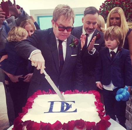 Elton John và David cùng hạnh phúc cắt bánh cưới.