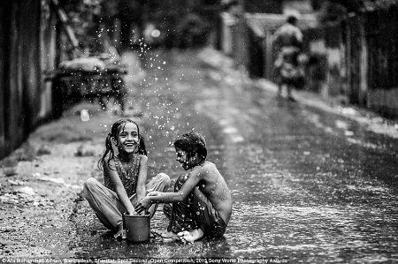 Hai cô bé sống trong
khu ổ chuột ở Bangladesh đang thích thú tắm mưa. (Ảnh: Ata Mohammad Adnan)