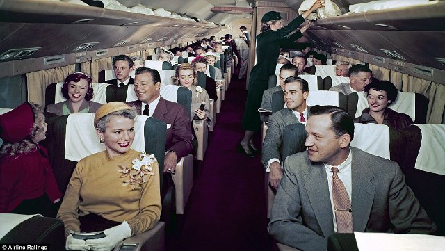
Hành khách chờ cất cánh trong cabin của máy bay Douglas DC-7. Phụ nữ đeo găng tay, mặc váy, đội mũ, trong khi những người đàn ông trong trang phục vest và thắt cà vạt.

