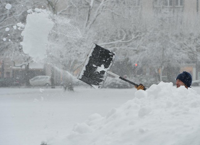 Một người đàn ông đang dọn tuyết, trong khi tuyết vẫn không ngừng rơi ở Wiesbaden, Đức, ngày 27/12. (Ảnh: Arne Dedert/AP)