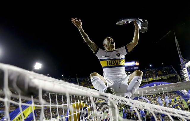 
Phấn khích với chức vô địch, Tevez đã trèo lên nóc lưới giơ cao chiếc cúp

