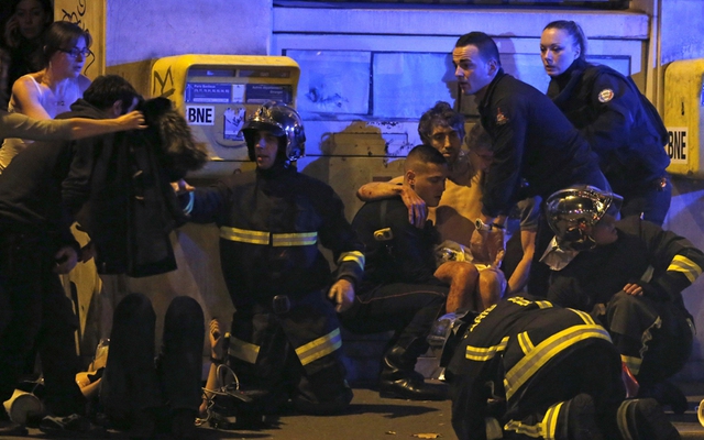 
Các nhân viên cứu hộ giải cứu cho nạn nhân bị thương ở khu vực gần nhà hát Bataclan (Ảnh: Reuters)
