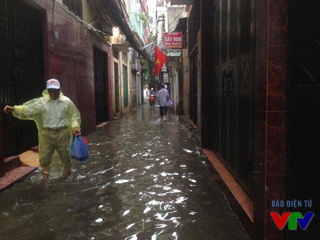 
Tại phố Khương Thượng, người dân phải lội qua sông để về nhà.
