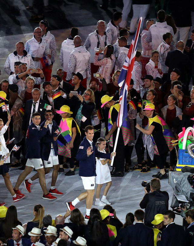 
Andy Murray vẫy chào khán giả và chỉ cần một tay để cầm lá cờ Vương quốc Anh

