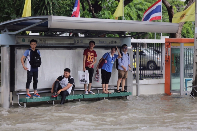 
Học sinh, sinh viên tới trường gặp nhiều khó khăn do nước ngập sâu trên đường.
