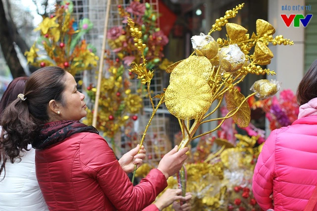 
Ngoài đồ lễ, nhiều người còn chọn lựa và mua sắm hoa giả, các loại cành vàng, lá ngọc để trang trí trong dịp Tết Nguyên đán sắp tới.

