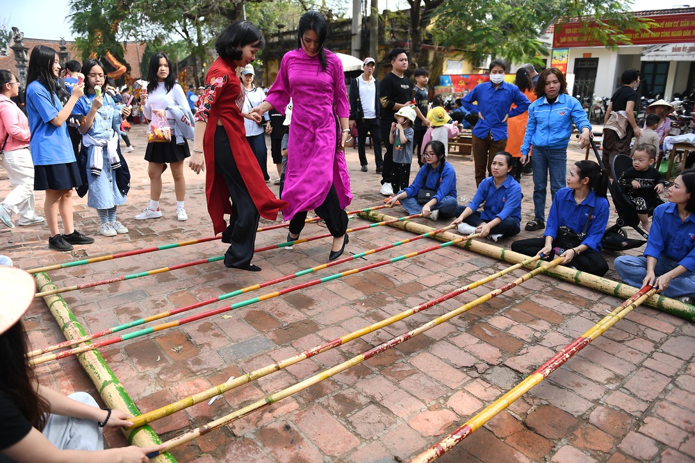 Khách nước ngoài học gói bánh chưng, xem múa rối nước ở Tết làng Việt 2024 - Ảnh 3.