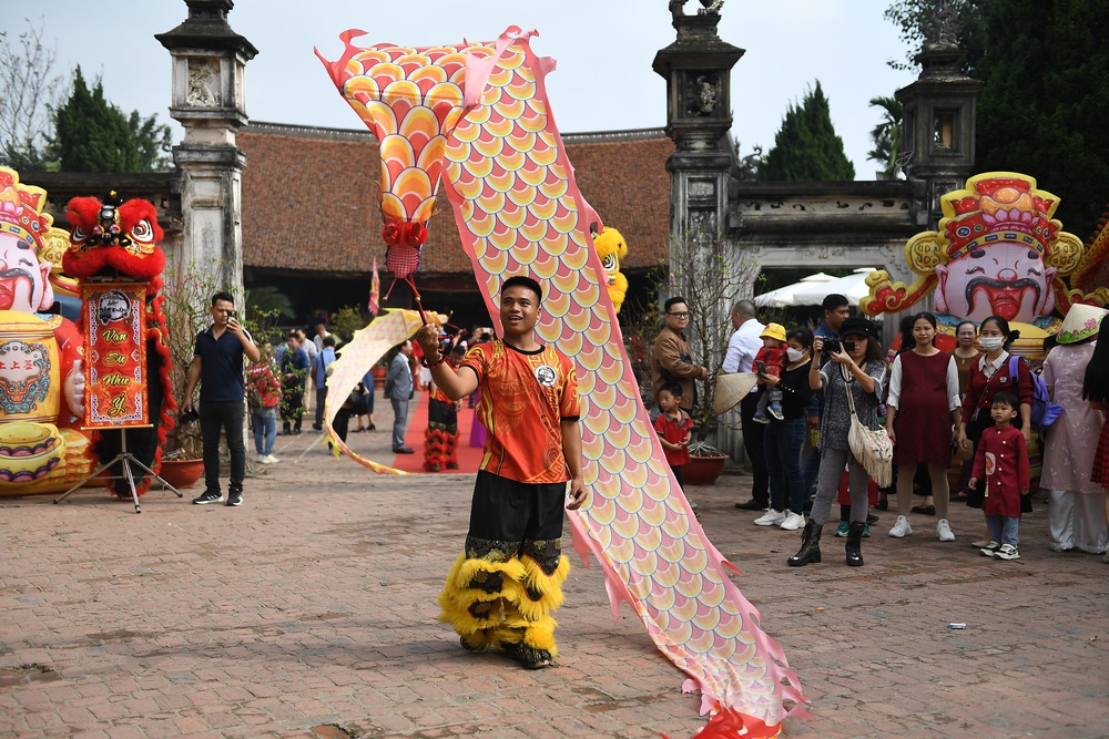 Khách nước ngoài học gói bánh chưng, xem múa rối nước ở Tết làng Việt 2024 - Ảnh 6.