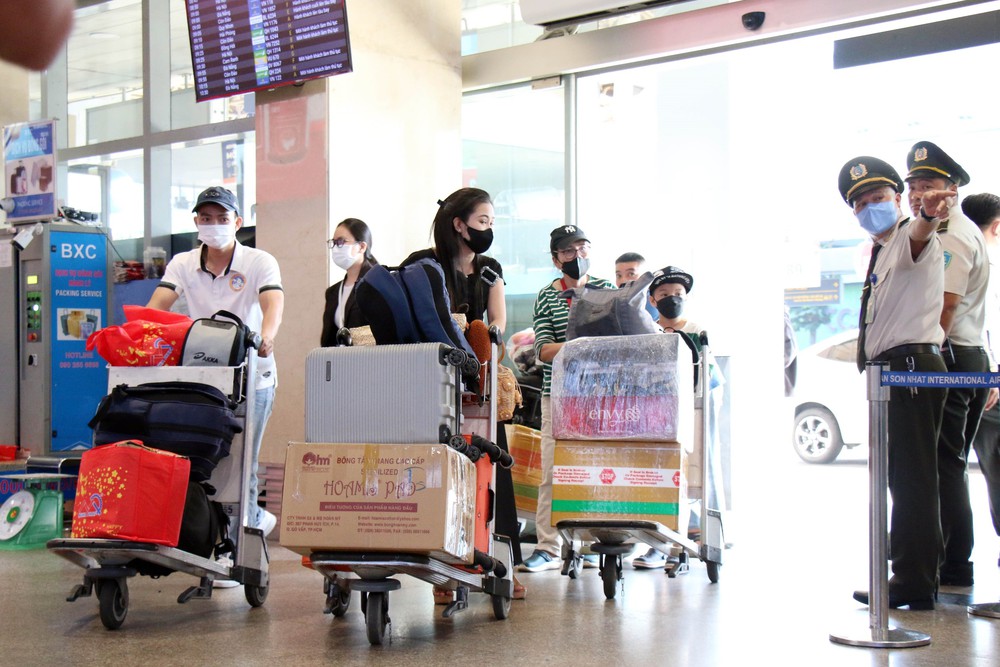 Sân bay Tân Sơn Nhất chật kín người về quê đón Tết - Ảnh 1.