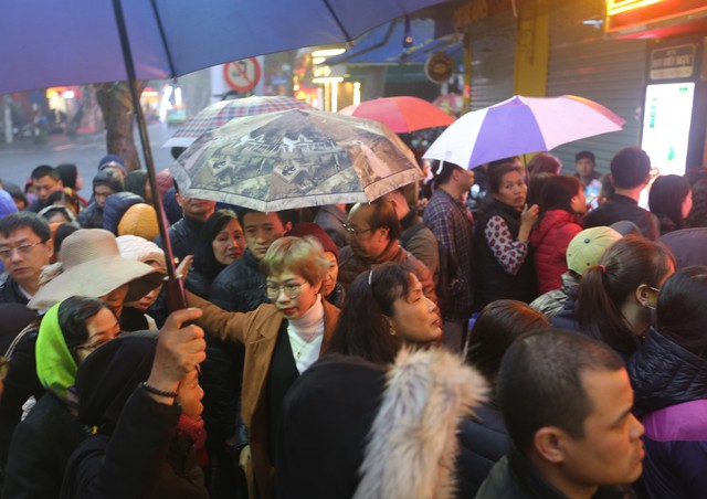 Ngày Thần Tài: Mặc mưa lạnh, người dân xếp hàng chờ mua vàng - Ảnh 1.