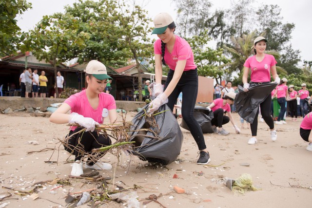 Thí sinh Hoa hậu Việt Nam 2018 dọn rác trên bãi biển Cửa Lò sau bão số 3 - Ảnh 1.