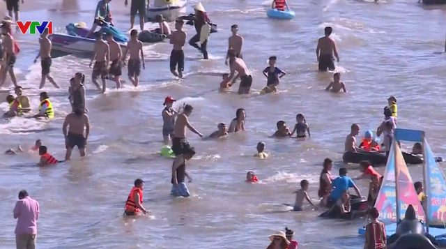 Nắng nóng, bãi biển Sầm Sơn đông nghịt người tắm giải nhiệt - Ảnh 1.