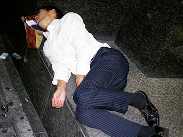 Doanh nhân Nhật Bản ngủ gật ở lề đường do làm việc quá sức - Ảnh 1.