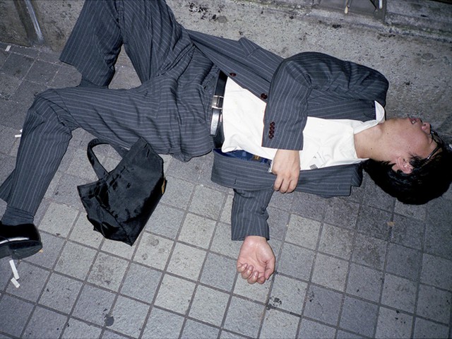 Doanh nhân Nhật Bản ngủ gật ở lề đường do làm việc quá sức - Ảnh 2.