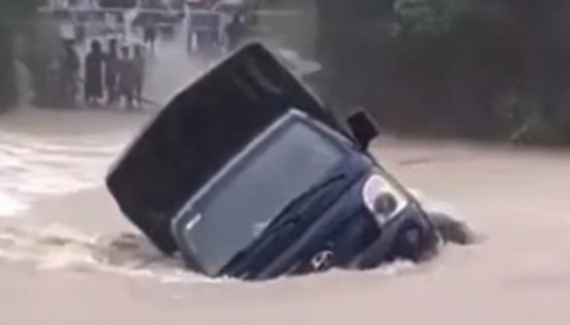 VIDEO: Xe tải bị nước lũ cuốn trôi khi đi qua đập tràn - Ảnh 1.