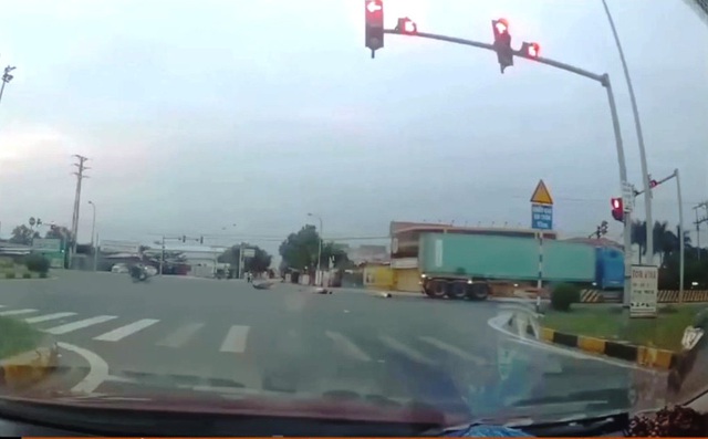 Vượt đèn đỏ, đôi nam nữ đi xe máy đâm ngang sườn xe container - Ảnh 2.