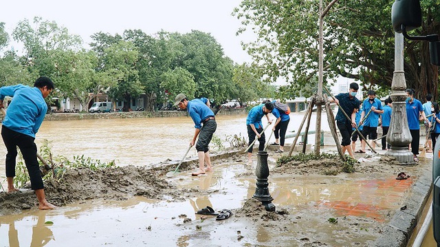 
Youth Union members clean up a road in Thua Thien Hue after floodwater recedes. (Photo: VNA)
