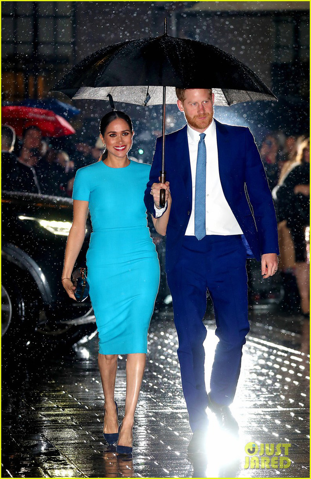 Cầm ô đi dưới mưa, vợ chồng hoàng tử Harry khiến dân tình sững sờ - Ảnh 1.