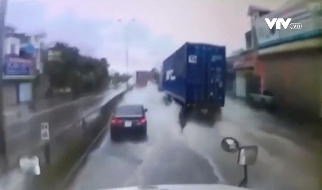 Dừng giữa đường khi trời mưa, xe 4 chỗ suýt bị xe container tông trúng - Ảnh 1.