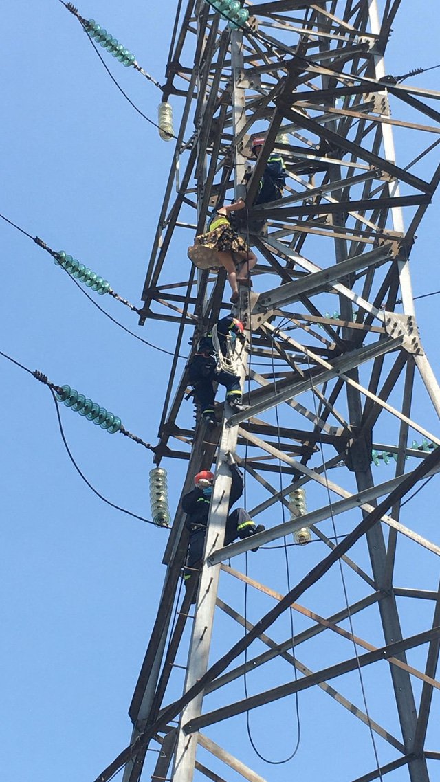 Giải cứu người phụ nữ leo lên cột điện cao thế khoảng 100 mét - Ảnh 1.