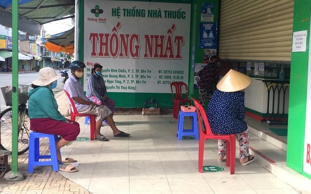 
People in Ben Tre Province follow the strict social distancing rule when going to buy medicine. (Photo: NDO)
