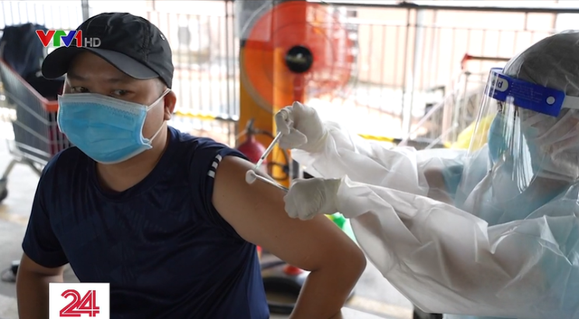 Người dân TP Hồ Chí Minh tranh thủ tiêm vaccine để được cấp thẻ xanh COVID-19 - Ảnh 1.