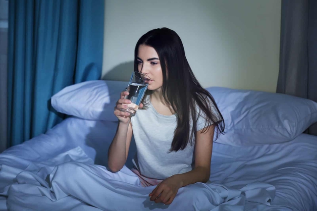 Lợi và hại của việc uống nước trước khi đi ngủ - Ảnh 1.