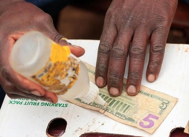 Nghề sửa, vá tiền USD cũ ở Zimbabwe - Ảnh 1.