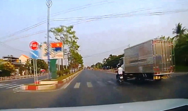 Đi sai làn, người lái xe máy va chạm với xe tải, ngã lăn xuống đường - Ảnh 1.