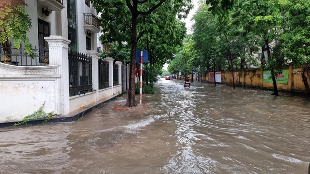 Mưa trắng trời, đường phố Hà Nội biến thành sông - Ảnh 2.