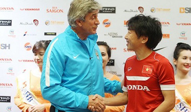 Vietnam's coach Toshiya Miura (R) shakes hands with his Manchester City counterpart Manuel Pellegrini at the end of a press conference in Hanoi on July 26, 2015.