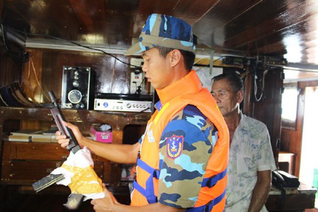 A Vietnamese coast guard inspects a gun on the Thai ship. Photo credit: Vietnam Coast Guard