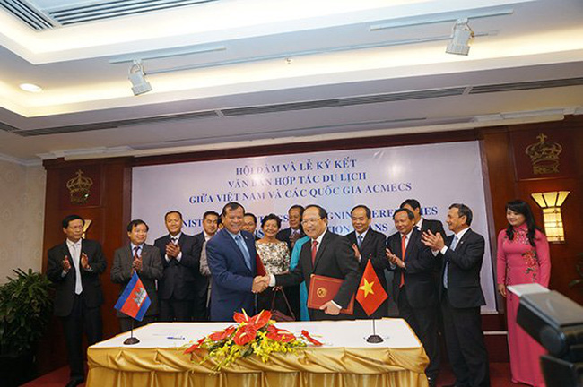 Vietnam’s Minister of Culture, Sports and Tourism Hoang Tuan Anh (R) shakes hands with Cambodia’s Minister of Tourism Thong Khon at a MOU signing ceremony in HCMC - PHOTO: DAO LOAN