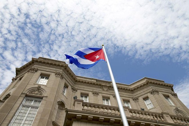 The Cuban national flag is seen raised over their new embassy in Washington, July 20, 2015