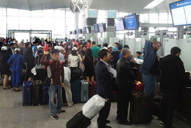 Passengers wait for their turns to complete procedures at Noi Bai International Airport in Ha Noi. (Photo: VNA)