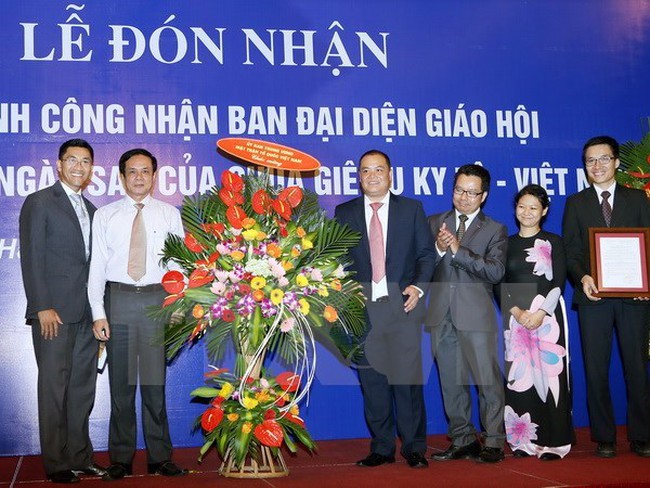 Vice President of Vietnam Fatherland Front Central Committee Le Ba Trinh presents flowers to the representative committee (Source: VNA)