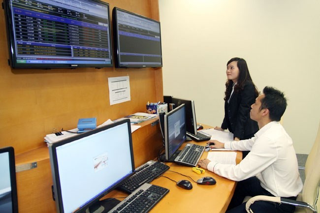 Hanoi Stock Exchange staff conduct check-ups on and supervise G-bond auctions. (Photo: VNA)