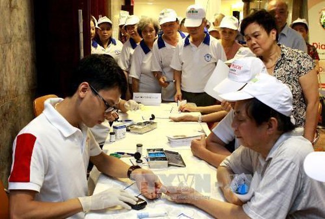 A doctor provides free checkup for people with high blood pressure. (Photo: VNA)