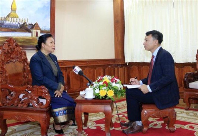 Head of the Lao Party Central Committee’s Commission for External Relations Sounthone Sayachac (L) and Vietnam News Agency's reporter