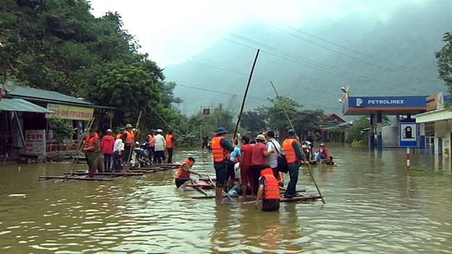 People use rafts to pass a flooded area on National Highway 6 in Hoa Binh province (Photo: VNA)