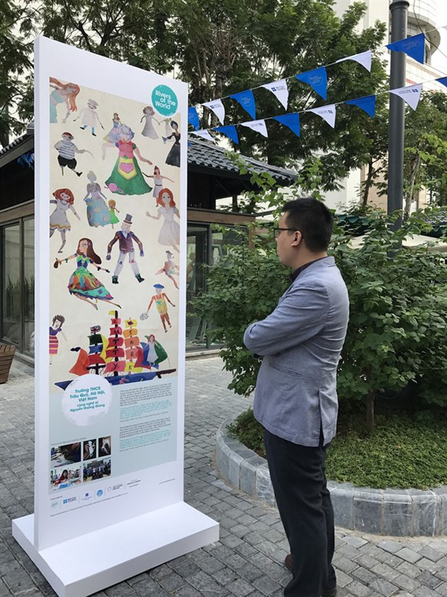 An exhibition visitor looks at a work of art by Trau Quy Secondary School’s students on Hanoi’s Book Street (Photo courtesy of British Council)