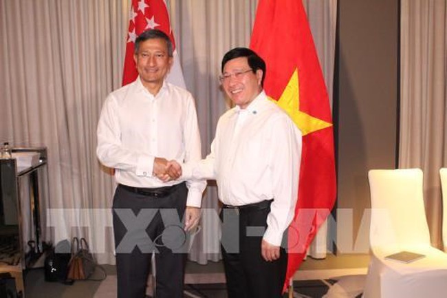 Deputy Prime Minister and Foreign Minister Pham Binh Minh (right) and Singaporean Foreign Minister Vivian Balakrishnan meet on February 5 on the sidelines of the ASEAN Foreign Ministers’ Retreat in Singapore. (Photo: VNA)