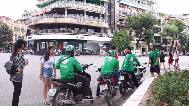GrabBike drivers are waiting for their customers near Hoan Kiem Lake in Hanoi.