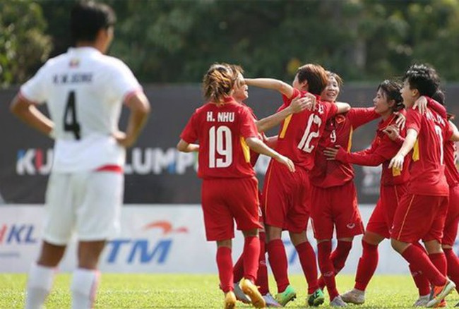 Members of Vietnam women's football team (in red) celebrate their goal