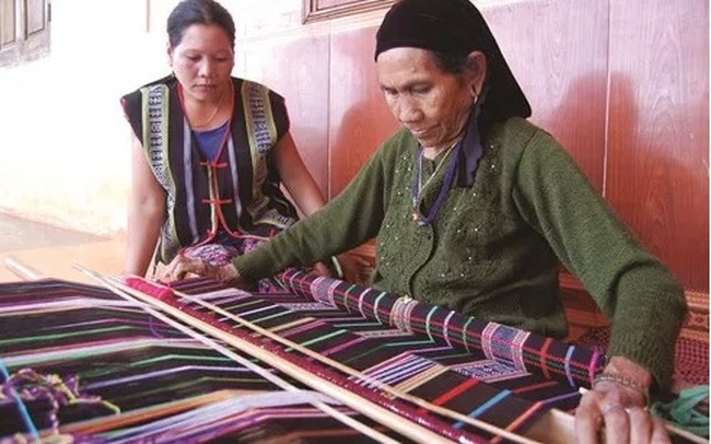 A M’nong ethnic elder weaving brocade in a traditional loom (Photo: dantocmiennui.vn)