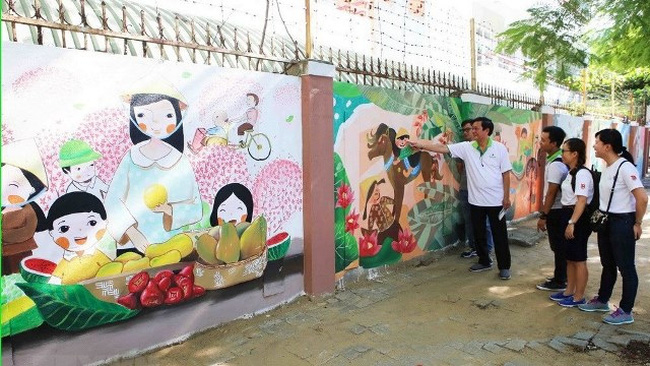 Locals admiring mural paintings at the inauguration of the project (Photo: VNA)
