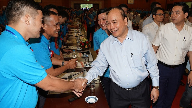 PM Nguyen Xuan Phuc shakes hands with the workers at the dialogue. (Photo: VGP)