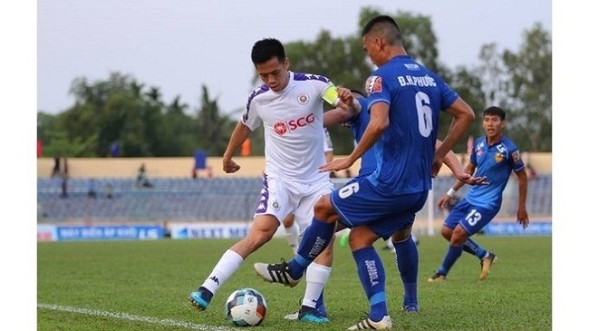 Hanoi FC's captain Van Quyet (in white) in action with a Quang Nam FC player.