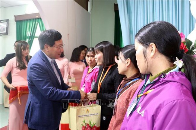 Deputy Prime Minister and Foreign Minister Pham Binh Minh presents gifts to workers at the Nam Duoc Ltd., Co., in Nam Dinh city’s Hoa Xa industrial park (Photo: VNA)